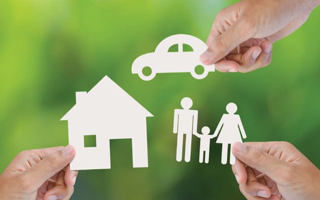 Hands holding cutouts of a house, a car and a family