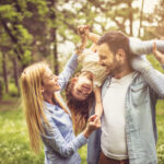 Happy smiling family spending summer day at park.